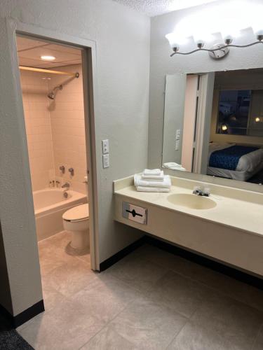 a bathroom with a sink and a toilet and a mirror at Travelodge by Wyndham Lincoln Northeast in Lincoln