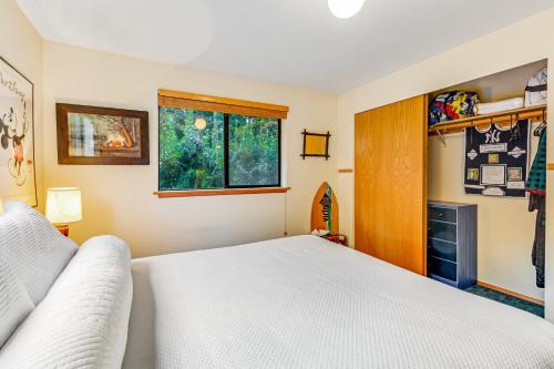 a bedroom with a white bed and a window at North Hood Canal House in Hansville