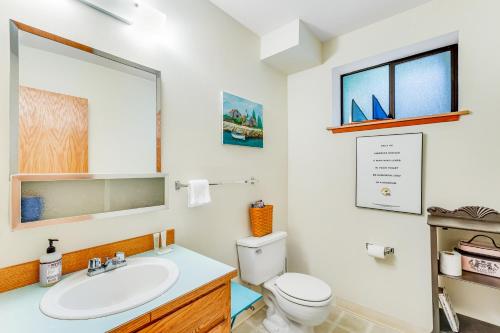 a bathroom with a sink and a toilet and a mirror at North Hood Canal House in Hansville