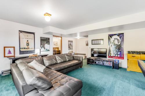 a living room with a leather couch and a flat screen tv at North Hood Canal House in Hansville