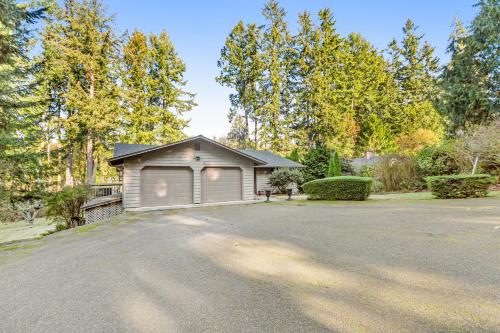 a house with a garage on the side of a driveway at North Hood Canal House in Hansville
