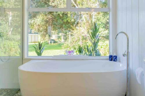 y baño con bañera y ventana. en Sunset Villa Norfolk Island - a Mediterranean inspired villa en Burnt Pine