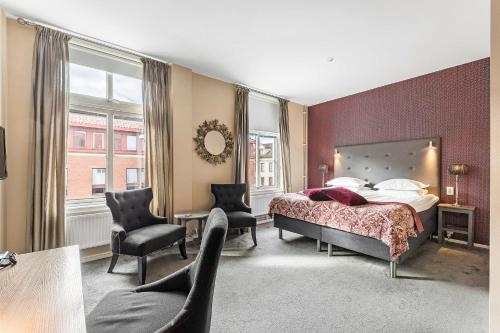 a hotel room with a bed and two chairs at Best Western Plus Edward Hotel in Lidköping