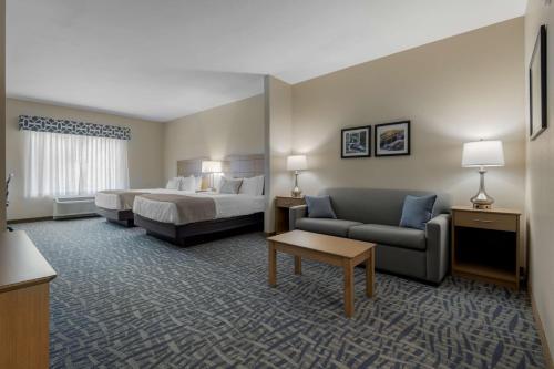a hotel room with a bed and a couch at Best Western Plus Rumford Falls in Rumford