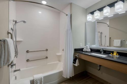 a bathroom with a tub and a sink and a shower at Best Western Plus Rumford Falls in Rumford