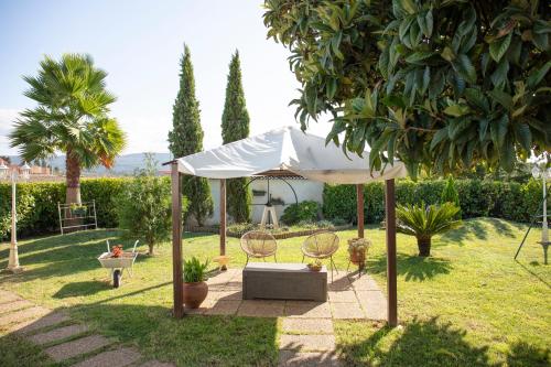 a white umbrella in a garden with two chairs and a table at Matouco Country House in Poços