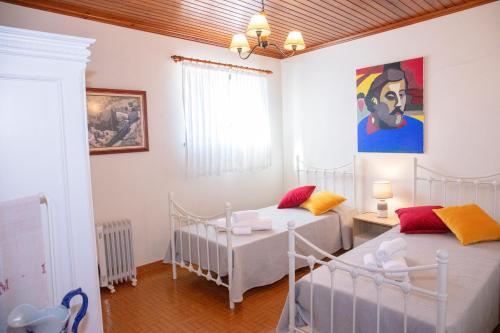 a bedroom with two beds and a painting on the wall at Matouco Country House in Poços