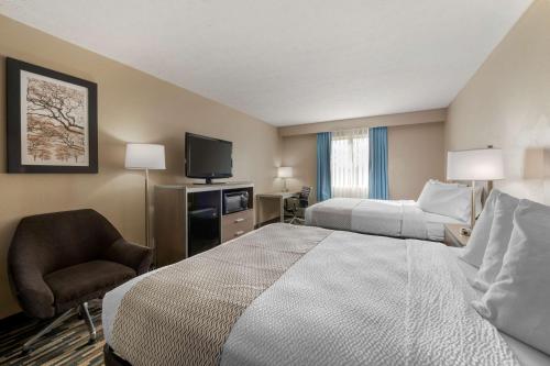 a hotel room with a bed and a chair at Best Western Edinburgh/Columbus in Edinburgh