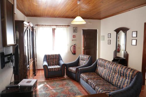 a living room with two couches and a tv at Matouco Country House in Poços