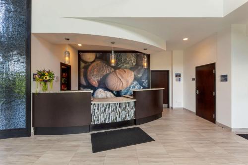 a lobby with a painting of vegetables on the wall at Best Western Premier Northwood Hotel in Timmins