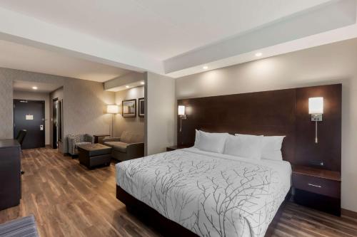 Habitación de hotel con cama y sala de estar. en Best Western Premier Northwood Hotel en Timmins