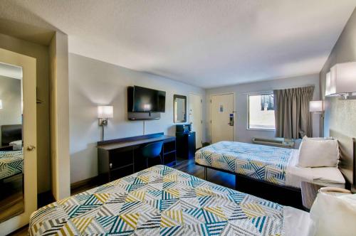 a hotel room with two beds and a desk at Studio 6 Birmingham, AL - Medical Center - Inverness Hwy 280 in Birmingham