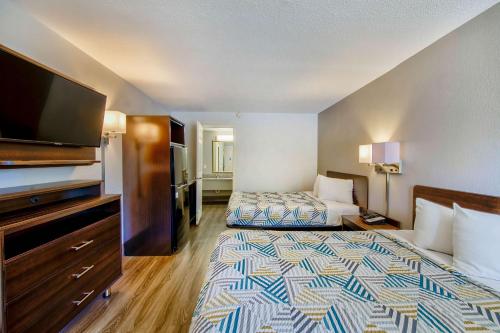 a hotel room with two beds and a flat screen tv at Studio 6 Birmingham, AL - Medical Center - Inverness Hwy 280 in Birmingham