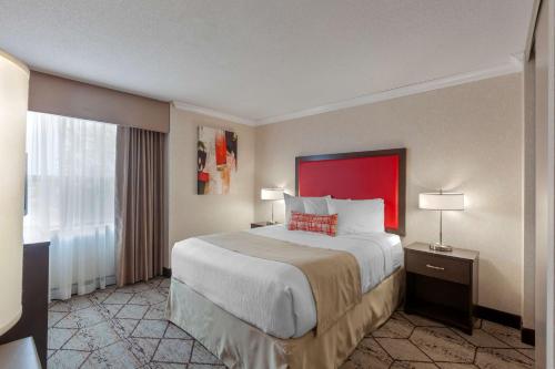 a hotel room with a large bed and a window at Best Western Plus Rose City Suites in Welland