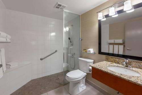 a bathroom with a toilet and a sink and a shower at Best Western Plus Rose City Suites in Welland