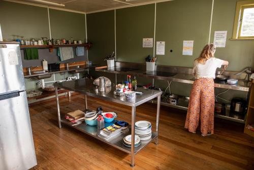 a woman standing in a kitchen preparing food at Solscape in Raglan