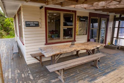 a wooden table on the porch of a store at Solscape in Raglan