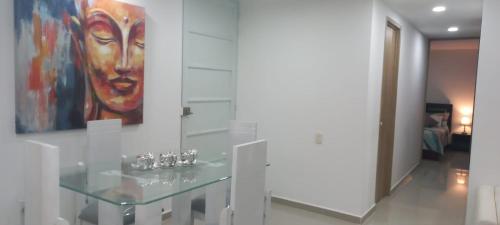 een glazen tafel in een kamer met een schilderij aan de muur bij Moderno amplio y acogedor apartamento en el sur de cali in Cali