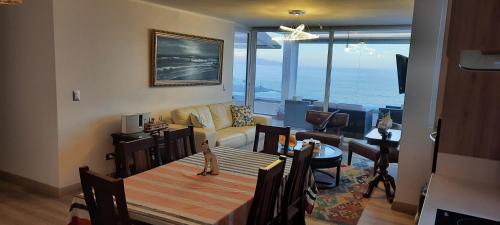 a living room with a dining table and a living room with the ocean at Depto equipado frente al mar. Excelente terraza in Viña del Mar