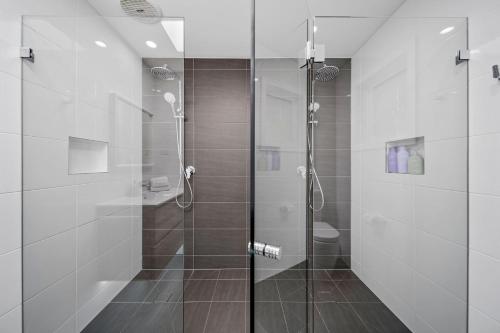 a bathroom with a shower with a glass door at Elements of Hyams in Hyams Beach