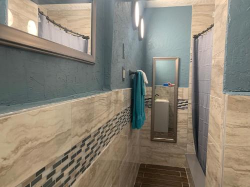 a bathroom with a mirror and blue walls at Michaels Surfside Cabanas in Clearwater Beach