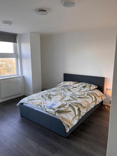 1 dormitorio con 1 cama en una habitación con ventana en The Serviced Accommodations, en Harlow