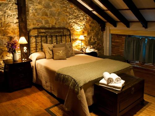 um quarto com uma cama e uma parede de pedra em Posada Santa Ana em Suances