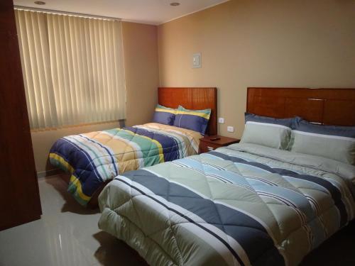 1 dormitorio con 2 camas y ventana en Matty House, en Lima