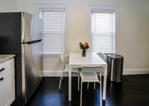 a kitchen with a white table and a refrigerator at Modern Three Bedroom Condo - Boston in Stoneham