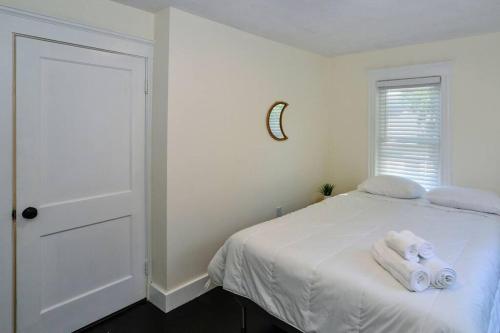 a bedroom with a white bed with towels on it at Modern Three Bedroom Condo - Boston in Stoneham