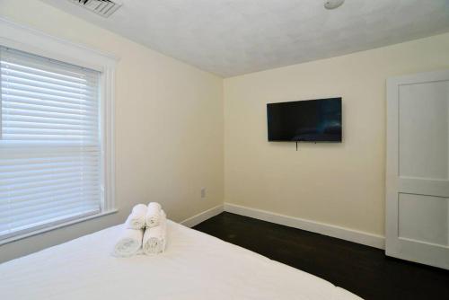 Un dormitorio con una cama con zapatos blancos. en Modern Three Bedroom Condo - Boston en Stoneham