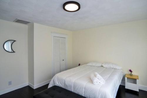a bedroom with a white bed with two towels on it at Modern Three Bedroom Condo - Boston in Stoneham