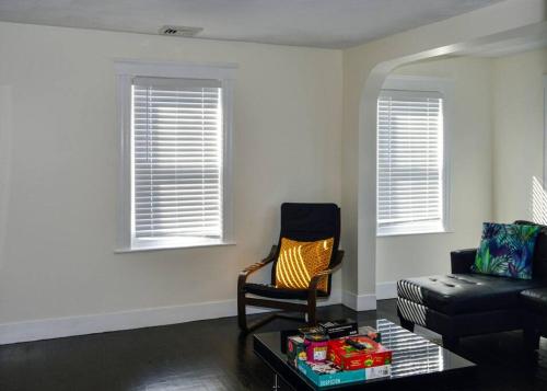 a living room with a chair and a couch at Modern Three Bedroom Condo - Boston in Stoneham