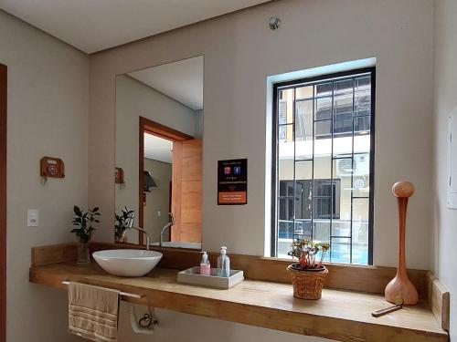 a bathroom with a sink and a large mirror at Pousada Casa Da Praia in Florianópolis