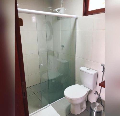 a bathroom with a toilet and a glass shower at Marinho Suítes Milagres in São Miguel dos Milagres