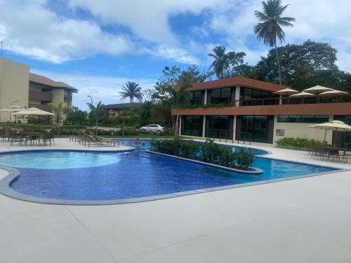 ein großes Schwimmbad vor einem Gebäude in der Unterkunft Flat térreo luxo 2qts Carneiros ao lado da igrejinha in Tamandaré