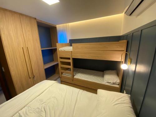 ein kleines Schlafzimmer mit einem Bett und ein Zimmer mit einem Etagenbett in der Unterkunft Flat térreo luxo 2qts Carneiros ao lado da igrejinha in Tamandaré