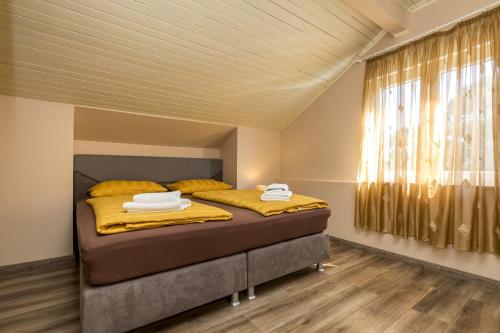 a bedroom with a bed with yellow sheets and a window at Rooms with a parking space Mali Losinj (Losinj) - 9681 in Mali Lošinj