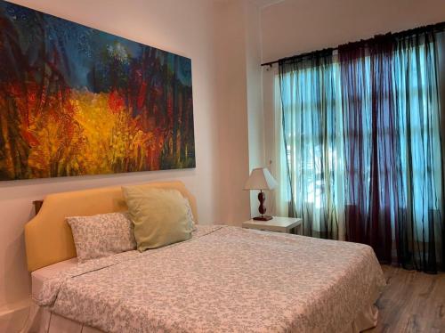 1 dormitorio con 1 cama y una gran pintura en la pared en Wesberly Apartments, en Kuching