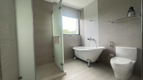 y baño con bañera, aseo y ducha. en Twelve Constellation Garden Resort, en Hengchun