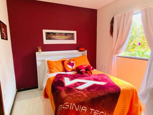 a red bedroom with a bed with a teddy bear on it at Villa Paradise in Brazil - Praia de Guaratiba Prado-BA in Prado