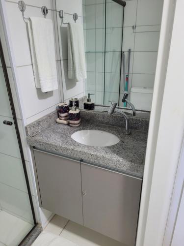 a bathroom with a sink and a mirror at Laguna Beach Flat in Porto De Galinhas