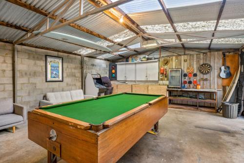 a garage with a pool table in a room at Cape Surf House in Cape Woolamai