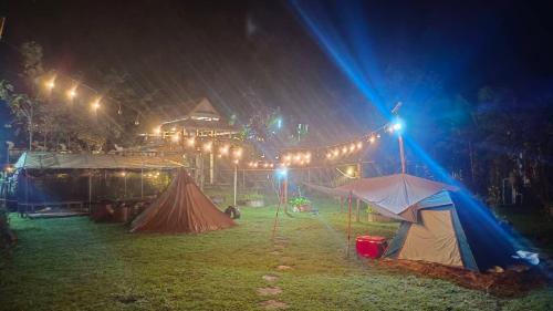 un grupo de tiendas de campaña bajo la lluvia por la noche en ปงอินรักษ์ฟาร์มสเตย์, en Hang Dong