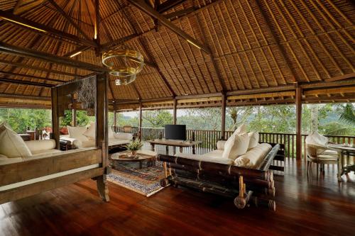 a pavilion with couches and chairs in a room at Villa Inka Ubud by Nakula in Ubud