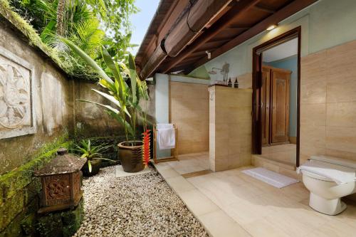 a bathroom with a toilet and a walk in shower at Villa Inka Ubud by Nakula in Ubud