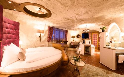 a bedroom with a large bed and a bathroom at Bergergut Geniesserhotel in Afiesl