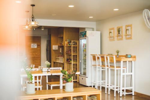 a kitchen with a refrigerator and a table and chairs at Pakping Hostel in Chiang Mai