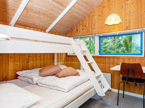 Etagenbett in einem Zimmer mit einer Leiter in der Unterkunft Holiday home Fårvang XIX in Fårvang