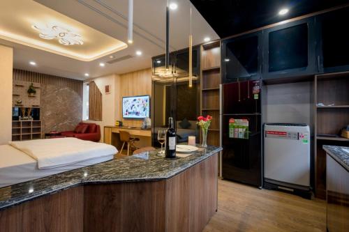 a room with a bed and a kitchen with a counter at BBQ HOSTEL in Ha Long